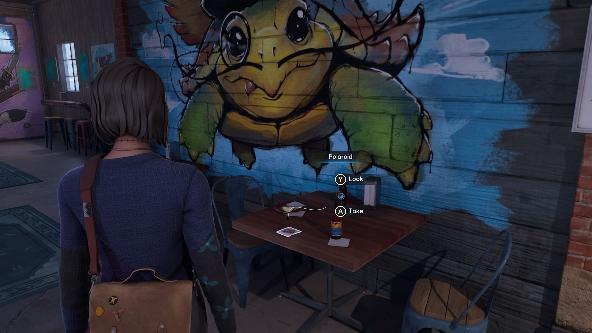 A screenshot with Max standing in front of the first Polaroid in Chapter 2, located on a table in a bar, right next to a mural of a snapping turtle wearing a monocle.