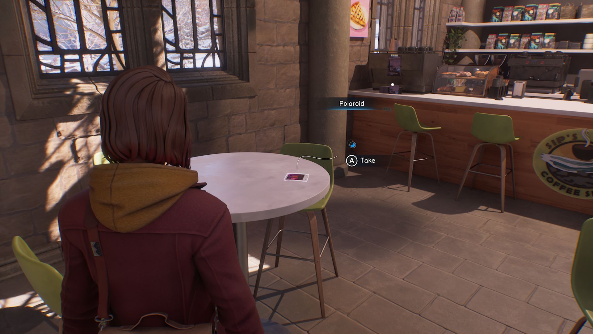 A screenshot with Max standing in front of the first Polaroid in Chapter 3, located on a circular table in a coffee shop.